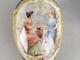 a blue vase with a picture of two women on it