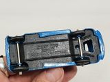 a person holding a blue and black toy car in their hand