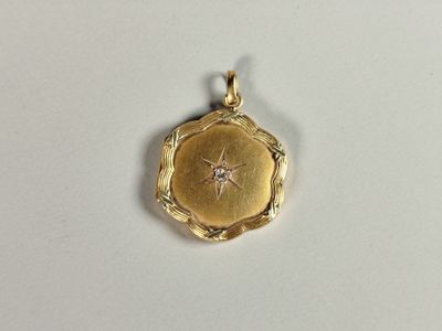 a close up of a gold locke with a diamond in the center