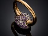 a close up of a gold ring with purple stones on it