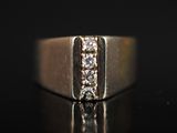 un gros plan d'une bague en or sertie de trois diamants sur un fond noir