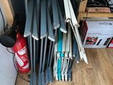 a pile of baseball bats sitting on top of a wooden shelf