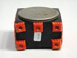 a coin sitting on top of a black and orange box