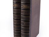 two old books sitting on top of each other on a white surface