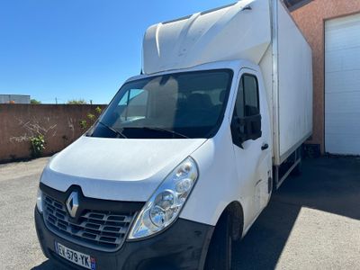une photo d'une camionnette blanche garée devant un garage