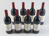 six bottles of red wine lined up in a row on a white surface
