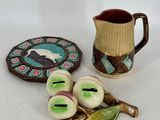 un pichet, une assiette et quelques autres objets posés sur une table
