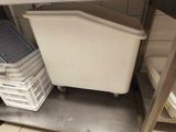 a white trash can sitting on top of a metal shelf