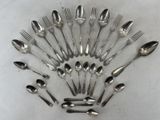 un grand nombre de cuillères et de fourchettes en argent disposées en cercle