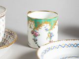 three cups and a saucer sitting on a table