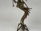 bronze statue of a woman holding a golf club and a golf ball