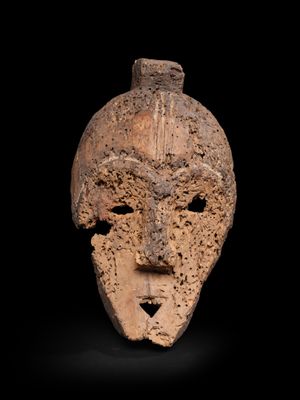 un gros plan d'un masque en argile sur fond noir