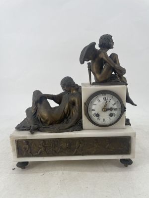 a statue of a man and a woman sitting on a clock