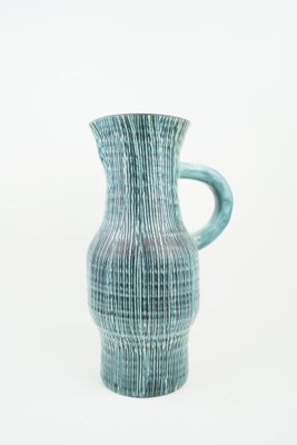 a blue vase that is sitting on a white surface