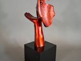 statue of a hand holding a piece of meat on a black base