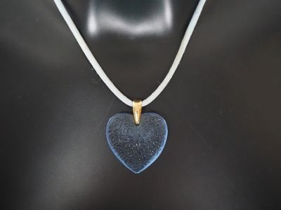 a close up of a necklace with a blue heart on it
