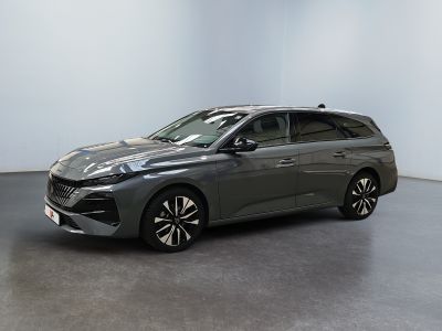 Une voiture grise est garée dans une pièce aux murs blancs.
