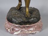 bronze statue of a woman holding a flower on a marble base