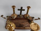 three candles on a wooden stand with a cross in the background