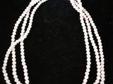 a close up of three strands of pearls on a black background