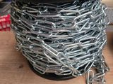 une bobine de chaîne posée sur une table à côté d'une paire de ciseaux