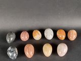 un ensemble de sept pierres de couleurs différentes posées sur une surface noire