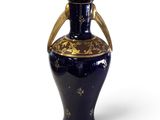 a blue vase with gold decoration on it on a white surface