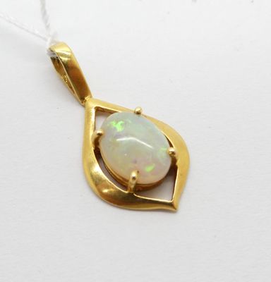 un gros plan d'un pendentif en oplite blanche posé sur une surface blanche