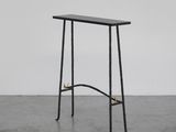 une table noire avec un piètement en métal et un plateau en bois
