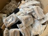 a cardboard box filled with bags of clothes and other items