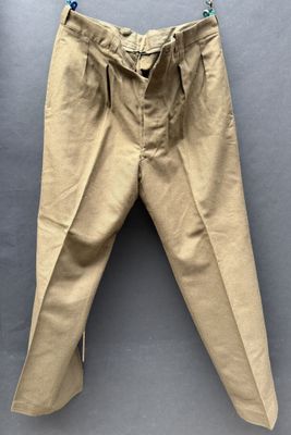 un vieux pantalon beige accroché au mur