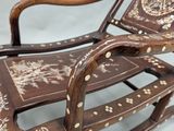 a wooden rocking chair with a brown and white design on it