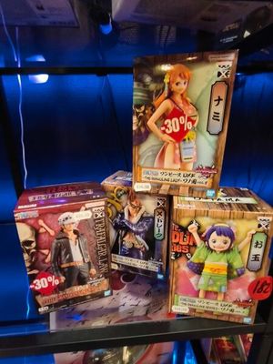 three boxes of anime figures on display in a display case