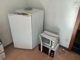 a small refrigerator and a microwave in a small room