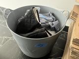 a bucket full of clothes sitting on a table next to a pile of boxes