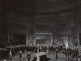 une vieille photo en noir et blanc montrant une foule de personnes dans un bâtiment