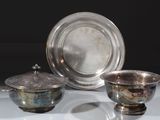 deux plats en argent et un bol en argent posés sur une table