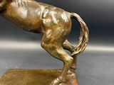 bronze statue of a horse on a base on a gray background
