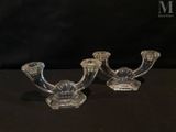 two clear glass candlesticks sitting on top of a black table