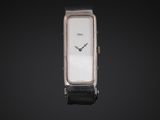 a close up of a watch on a black surface with a black background