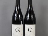 two bottles of wine sitting on top of a table next to each other