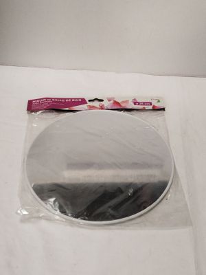 un miroir rond posé sur une table blanche