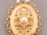 a gold locke with a pearl in the center