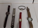 several watches and bracelets are on display in a display case