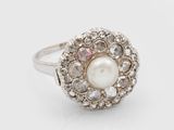 gros plan d'une bague en perles et diamants sur fond blanc