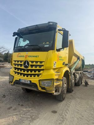 un gros camion jaune garé sur le bord de la route