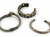 three pieces of silver jewelry on a white surface with a white background