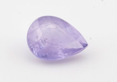 gros plan d'une pierre précieuse violette sur une surface blanche