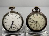 pair of antique pocket watches sitting on clear acrylic bases