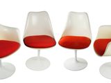 trois chaises blanches avec des coussins rouges et un piètement blanc